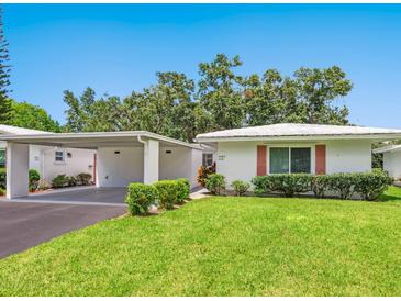 Charming single-story home with a well-maintained lawn and a convenient covered parking area at 4203 Schwalbe Dr # 115, Sarasota, FL 34235