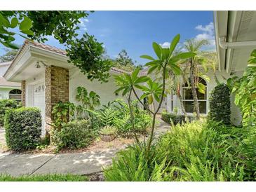 View of the front entrance surrounded by lush, tropical landscaping at 5803 Garden Lakes Palm, Bradenton, FL 34203