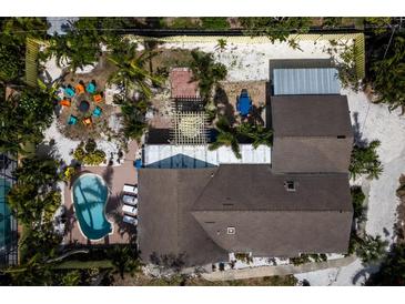 A serene aerial view reveals a private pool, verdant landscaping, and a cozy outdoor lounge area of the home at 8709 9Th Nw Ave, Bradenton, FL 34209
