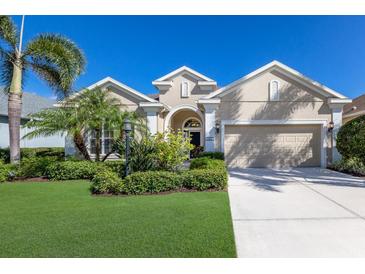 Charming home with a well-maintained lawn, mature palm trees, and an attached two-car garage, offering curb appeal and convenience at 11610 Griffith Park Ter, Bradenton, FL 34211