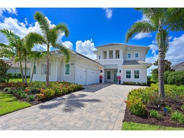 Beautiful two-story home with a paver driveway, lush landscaping, and a three-car garage at 17110 Verona Pl, Bradenton, FL 34202