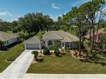 Well-maintained home with mature landscaping, tile roof, and a two-car garage on a sunny day at 2016 White Feather Ln, Nokomis, FL 34275