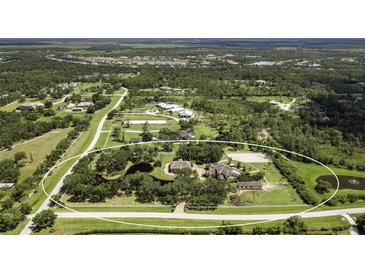 Sprawling estate with multiple buildings, mature trees, serene pond, and equestrian facilities nestled in a lush, green landscape at 21210 77Th E Ave, Bradenton, FL 34202