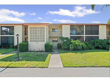 Well-manicured condo building with manicured lawn and tropical plants under a bright sky at 2415 Bayshore Gardens Pkwy # 2, Bradenton, FL 34207
