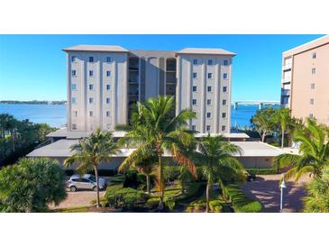 Beautiful building featuring lush tropical landscaping, a circular drive, and ample parking at 350 Golden Gate Pt # 61, Sarasota, FL 34236