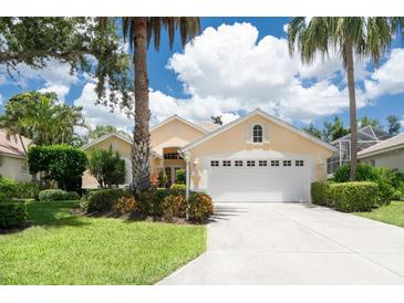 Charming single-story home with a well-manicured lawn, mature trees, and a two-car garage at 4374 Mirabella Cir, Bradenton, FL 34210