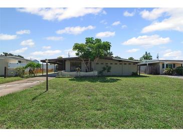 Charming single-story home featuring a well-maintained lawn and mature landscaping with a carport and inviting facade at 6707 Northampton Pl, Bradenton, FL 34207