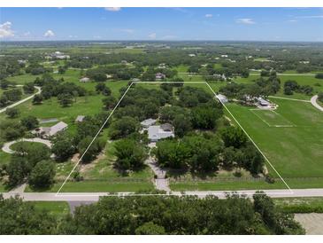 Expansive property featuring a lush green landscape with mature trees and a charming home, fully fenced at 7343 Palomino Trl, Sarasota, FL 34241