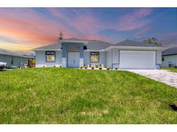 Charming single-story home featuring a well-manicured lawn and a two-car garage at 10443 Riverside Rd, Port Charlotte, FL 33981