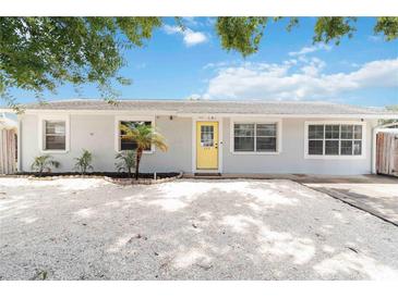 Charming single-story home with a bright yellow door, well-kept landscaping, and a gravel driveway at 111 66Th Street E Ct, Bradenton, FL 34208