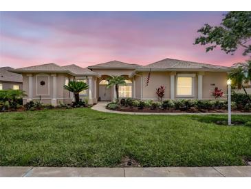 Charming single-story home with a well-manicured lawn and lush landscaping at 11328 Rivers Bluff Cir, Lakewood Ranch, FL 34202