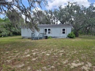 View of the home's exterior featuring a well-maintained yard and mature trees at 13023 Taylor St, Brooksville, FL 34613