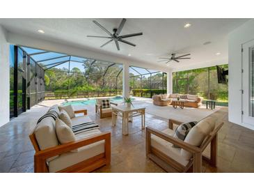 Spacious covered patio with comfortable seating, ceiling fans, and an outdoor pool at 14901 17Th E Ave, Bradenton, FL 34212