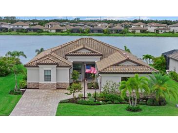 Beautiful single-Gathering home with a gorgeous yard, landscaping, and a glimpse of the serene lake in the background at 17320 Polo Trl, Bradenton, FL 34211