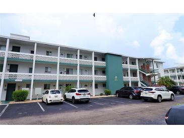 Three-story apartment building shows parking lot, exterior stairs, and a green-painted middle story at 1880 Sunny Dr # F35, Bradenton, FL 34207