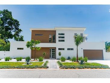 Modern two-story home featuring wood accents, a landscaped yard, and a striking entrance at 2124 Clematis Pl, Sarasota, FL 34239