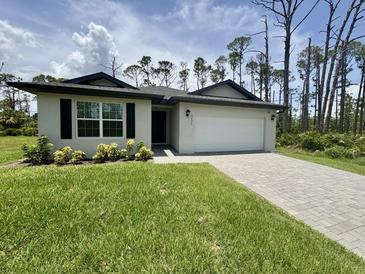 Charming single-Gathering home with a two-car garage and a well-maintained lawn and paved driveway at 2425 Maclachlan St, Port Charlotte, FL 33953