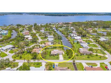 Aerial view of a charming home with a well-manicured lawn and water access via a canal in a waterfront community at 336 Highland Shores Dr, Ellenton, FL 34222