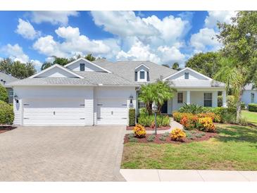 Charming single-story home with a well-manicured lawn, colorful flower beds, and a three-car garage at 4714 Seneca Park Trl, Bradenton, FL 34211