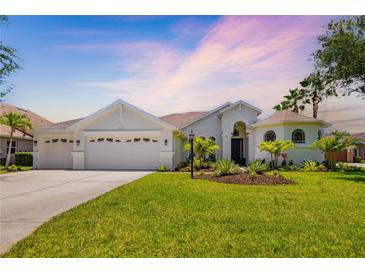 Beautiful single-story home with a well-manicured lawn and three-car garage at 7727 Heyward Cir, University Park, FL 34201