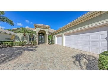 Elegant home featuring a three-car garage and lush landscaping at 8832 Enclave Ct, Sarasota, FL 34238