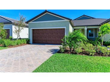 Charming home featuring a spacious two-car garage, well-manicured lawn, and a welcoming facade at 12827 Lily Quartz Loop, Parrish, FL 34219