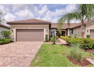 Charming single-story home featuring a tile roof, two-car garage, and lush landscaping at 17648 Northwood Pl, Lakewood Ranch, FL 34202