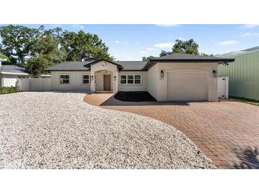 Charming single story home featuring a brick driveway, manicured landscaping, and attached garage at 1881 Orchid St, Sarasota, FL 34239