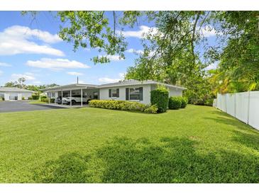 Well-maintained home with green lawn, covered parking, and manicured shrubs enhancing its curb appeal at 2115 9Th W Ave # 3D, Bradenton, FL 34205