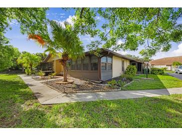 Charming corner home featuring a landscaped yard, mature trees, and a screened-in porch for relaxing outdoors at 4153 66Th Street W Cir # 4153, Bradenton, FL 34209