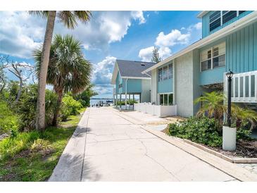 Inviting waterfront condo featuring a private walkway and a calming light blue exterior at 6005 N Beach Rd # 16, Englewood, FL 34223