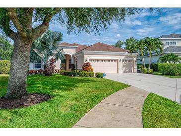 Charming home featuring a three-car garage, beautiful landscaping, and well-manicured lawn at 6610 Rosy Barb Ct, Lakewood Ranch, FL 34202