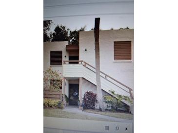 Inviting two-story condo with stairs leading to the entrance and well-maintained landscaping at 137 Pineneedle Dr # 137, Bradenton, FL 34210