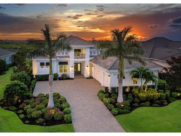 Elegant two-story home featuring a beautiful stone driveway, manicured landscaping, and a welcoming front entrance at 16917 Clearlake Ave, Lakewood Ranch, FL 34202