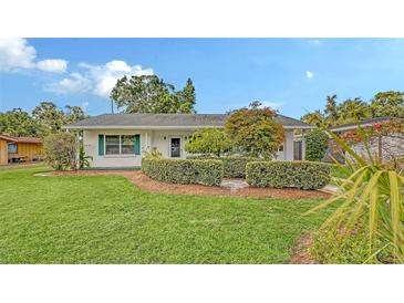 Charming home featuring lush lawn, verdant hedges, and well-maintained landscaping at 2088 Grove St, Sarasota, FL 34239