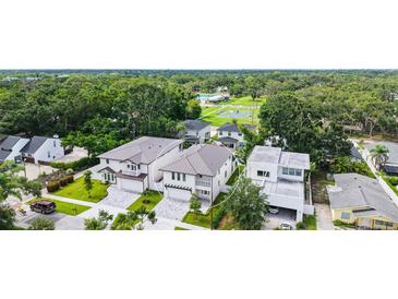 An aerial view shows a white two-story home with a well-manicured lawn and an attached two-car garage at 2590 Floyd St, Sarasota, FL 34239