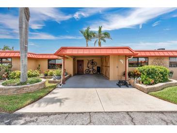 Charming home featuring well-kept landscaping, an orange roof, and a covered carport at 3850 Catalina Dr, Bradenton, FL 34210