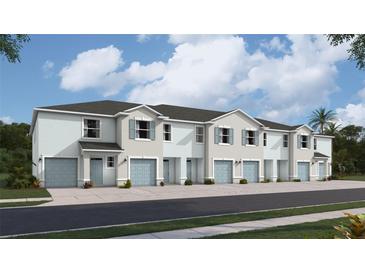 Charming townhouse exterior with individual garages, light blue doors, and beautifully landscaped surroundings at 4104 Gold Dust Ln, Sarasota, FL 34243