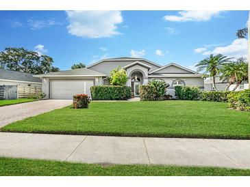 Charming single story home with lush lawn, mature landscaping, brick driveway, and attached two car garage at 5206 19Th W Ave, Bradenton, FL 34209