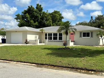Charming single-story home featuring a manicured lawn, pink front door and a one-car garage at 544 Mount Vernon Dr, Venice, FL 34293