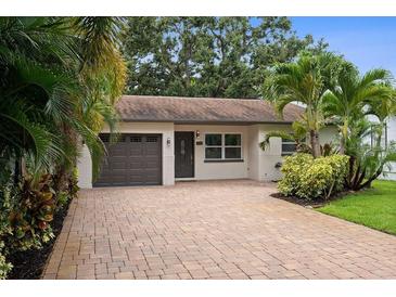 Charming single-story home with a well-maintained brick driveway and lush tropical landscaping at 5702 Tangerine S Ave, Gulfport, FL 33707