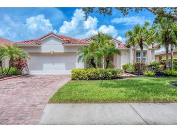 Charming single-story home featuring a lush lawn, red tile roof and a brick driveway at 6312 41St E Ct, Sarasota, FL 34243