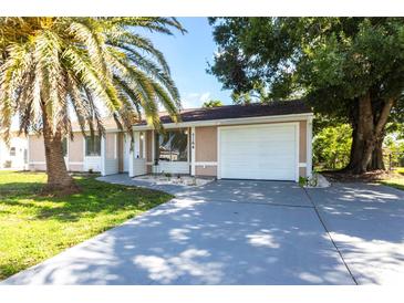 Charming single-story home featuring a well-maintained lawn, a palm tree, and an attached two-car garage at 7164 Gama Ct, North Port, FL 34287