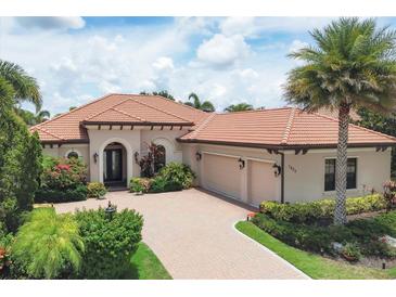 Well-maintained, charming one-story home featuring a tile roof, beautiful landscaping, and a brick driveway at 7605 Haddington Cv, Lakewood Ranch, FL 34202