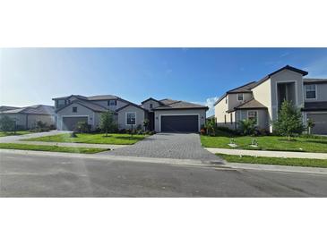 Beautifully landscaped homes with paved driveways create an inviting street view at 15115 Oxford Grey Dr, Bradenton, FL 34211