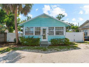 Charming, light blue single-story home with ample windows and a well-maintained front yard and a palm tree at 1911 26Th W St, Bradenton, FL 34205