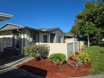 Charming exterior view of a well-maintained property, featuring a freshly mulched garden area and a light beige privacy fence at 2606 29Th Ave W # 12, Bradenton, FL 34205