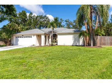 Charming one-story home with a well-manicured lawn and mature trees, enhancing its curb appeal at 4805 Cypress Lake Ct, Sarasota, FL 34243