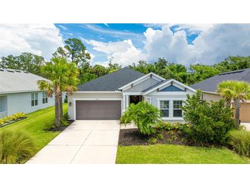Charming single-story home featuring a two-car garage, well-manicured lawn, and mature landscaping at 5927 Maidenstone Way, Palmetto, FL 34221