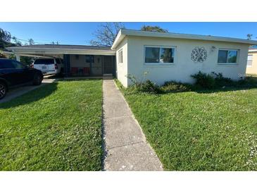 Charming single-story home with a well-manicured lawn and a covered front patio at 6048 Merril St, North Port, FL 34287